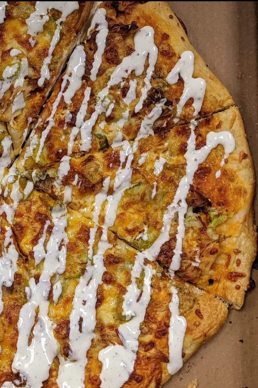Pizza drizzled with ranch.
