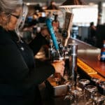 Hitching Post Server pouring beer