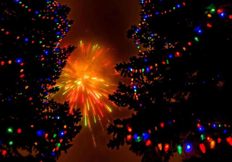 Fireworks through lighted Christmas Trees